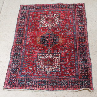 A red and blue ground Persian Karajeh rug with stylised medallion to the centre and overall geometric design 76" x 58" 