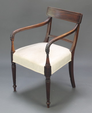 A Georgian mahogany open arm carver chair with plain mid rail, carved arms and over stuffed seat, raised on turned reeded supports 