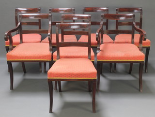 A set of 8 Georgian mahogany bar back dining chairs with over stuffed seats, raised on sabre supports 