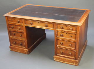 A Victorian pine "estate" kneehole desk with inset writing surface, above 1 long and 8 short drawers with tore handles, 1 pedestal fitted a cupboard 27 1/2"h x 52 1/2"w x 29 1/2"d 
