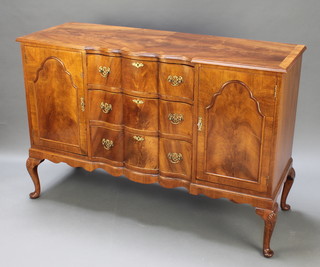 A Georgian style shaped walnut sideboard with crossbanded top fitted 3 long drawers flanked by cupboards raised on cabriole supports 36" x 53" x 19"