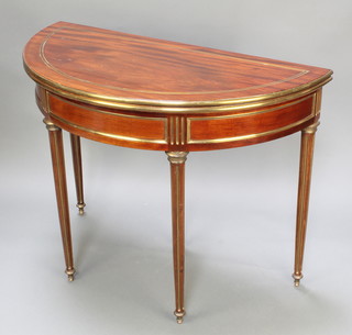 An Empire style mahogany and brass inlaid D shaped card table raised on turned and fluted supports 39 1/2"h x 39"w x 19 1/2"d 