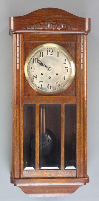 A 1930's 8 day chiming wall clock with silvered dial and Arabic numerals contained in an oak case 
