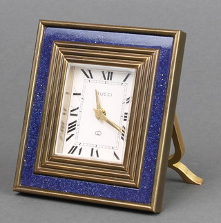 A Gucci 8 day alarm clock with enamelled dial and Roman numerals contained in a blue enamelled and gilt metal case 