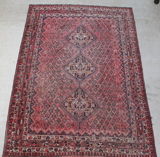 A red ground Persian rug with 2 stylised diamonds to the centre within a multi row border 121" x  80 1/2" 