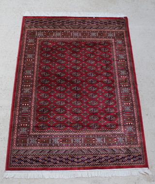 A Belgian cotton red ground Bokhara style rug with numerous octagons to the centre within multi row border 75" x 53" 