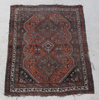 A Caucasian style rug with stylised diamonds to the centre within a multi row border 57" x 46", some wear and damage to the edge 
