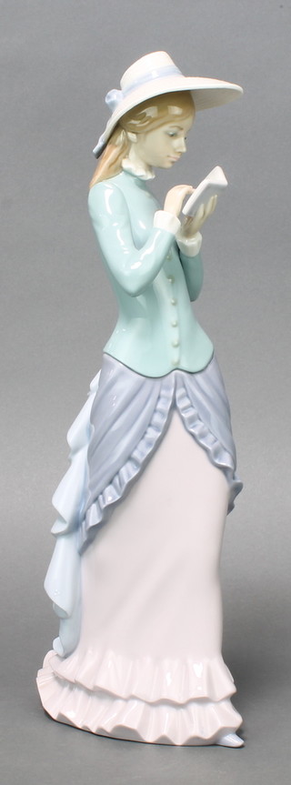 A Lladro figure of a standing lady reading a book 14" 