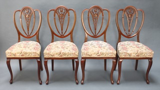 A set of 4 Edwardian mahogany "shield back" dining chairs with pierced shaped backs, raised on cabriole supports