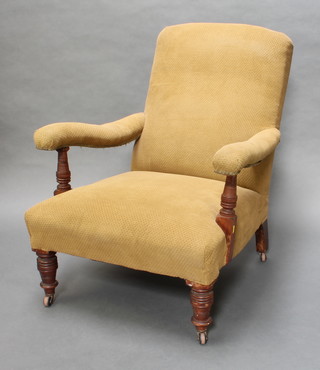 A Victorian mahogany framed Howard style open arm chair, upholstered in green material 