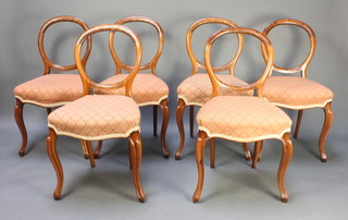 A set of 6 Victorian carved mahogany balloon back dining chairs the seats of serpentine outline, raised on cabriole supports 