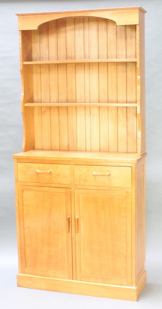 A Cotswold style light oak dresser, the raised back fitted 2 shelves, the base fitted 2 long drawers above double cupboard enclosed by panelled doors 79"h x 36"w x 13"d 