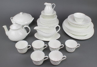 A Wedgwood white glazed spiral decorated dinner service and tea service comprising 11 small plates, 6 medium plates, 7 dinner plates, 5 soup bowls, a meat plate, sauce boat and stand, tureen and cover, teapot, 7 tea cups, 6 saucers, milk jug and sugar bowl 