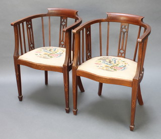 A pair of Edwardian inlaid mahogany tub back chairs with shaped seats, raised on square tapering supports