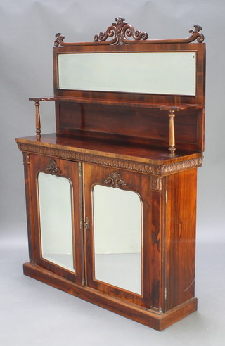 A William IV rosewood chiffonier, the raised mirrored back fitted a shelf and carved apron, the base fitted a cupboard enclosed by arched panelled doors 65"h x 48"w x 14"d 