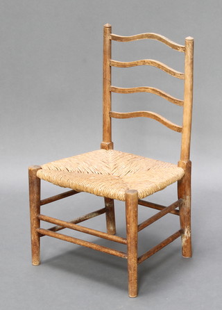 A child's beech ladder back chair with woven rush seat 
