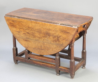 An 18th Century oak oval drop flap gateleg dining table raised on turned and block supports 26 1/2"h x 42w x 15 1/2" when closed x 49" when open 