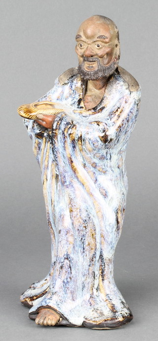 A Chinese slip glazed figure of a gentleman holding a shoe 10" 