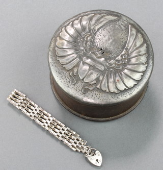 An Art Nouveau wooden and pewter dressing table jar the lid decorated a scarab 3 1/2" diam. (some holes to the lid) containing a silver gate bracelet and studs 