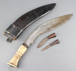 A Kukri with 12" blade and bone handle contained in a leather scabbard with 2 associated skinning knives 
