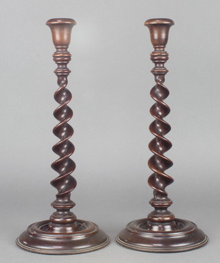 A pair of spiral turned mahogany candlesticks with metal sconces 13 1/2" 