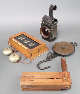A Chapman Bros. GPO issue red hand lantern marked 1949, a Salters 2lb spring balance, a rectangular 3 aperture servants indicator board - Tradesman, Office, Maisonette connected with 2 bells and a Second World War wooden ARP rattle marked 1939 (handle f)  
