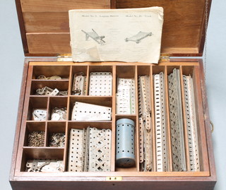 An oak box containing a large collection of steel coloured Meccano 