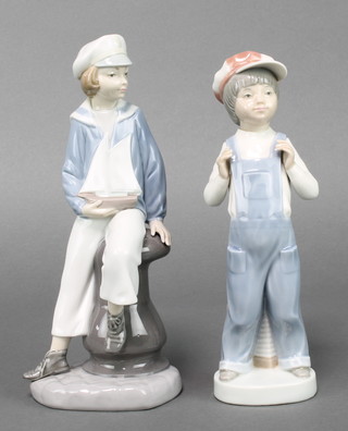 A Lladro figure  boy wearing dungarees 8 1/2" and a boy in a sailor suit holding a model yacht 9" 