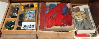 Two wooden boxes containing a collection of red and blue Meccano, a cardboard box containing steel coloured Meccano, 1 other containing red and green Meccano and a plastic tray containing red wheels etc  