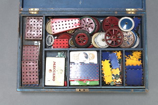 A blue painted wooden box marked Meccano, the lid marked Meccano No.5 containing various blue and red pieces of Meccano 