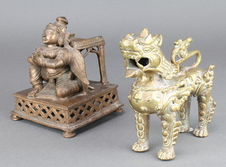 A Chinese gilt bronze dog of fo 8" together with an Eastern bronze stand of a kneeling attendant 5" h x 4" x 4" 