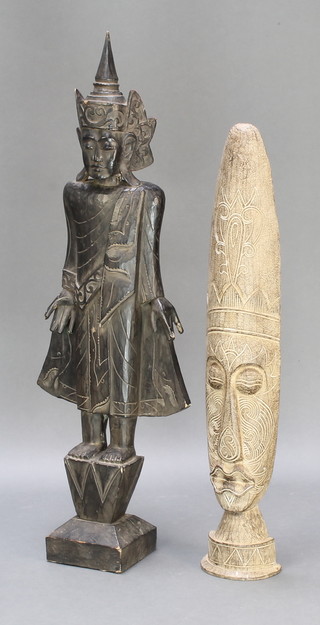 A carved wooden figure of a standing deity raised on a square base 47" and a carved African mask 38" 