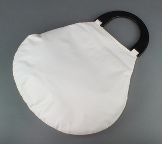 A Donna Karan round shaped handbag in white nappa leather with black handles, monogrammed lining and complete with dust cover 14" x 14"  
