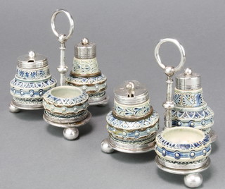 Martin Brothers, A rare pair of 3 piece stoneware condiments with geometric decoration and stylised leaves, each comprising a pepper, salt and mustard with silver mounts on trifoil stands. Inscribed R W Martin, London 2 - 1875 with one silver spoon, silver maker George W Adams, London 1875