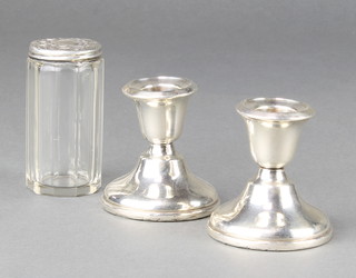 A pair of dwarf silver candlesticks Birmingham 1946 2 1/2" together with a silver mounted toilet bottle