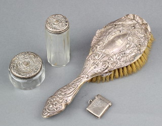 An Edwardian silver vesta with chased decoration Birmingham 1904 together with 2 silver mounted bottles and a ditto hair brush 