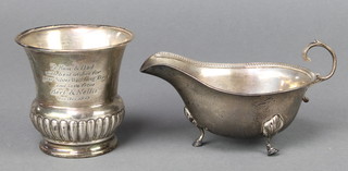 A silver sauce boat with S scroll handle on hoof feet Birmingham 1942 together with a demi-fluted beaker with inscription and rubbed marks, 130 grams