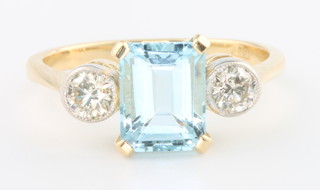 An 18ct yellow gold aquamarine and diamond ring the centre baguette cut stone 1.8ct flanked by 2 brilliant cut diamonds approx. 0.4ct, size N 