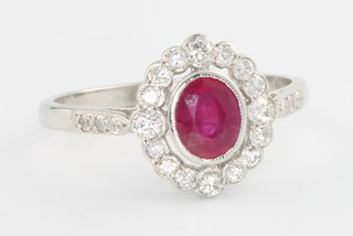 An 18ct white gold oval ruby and diamond ring, the centre stone approximately 0.85ct surrounded by brilliant cut diamonds 0.35ct size P 1/2