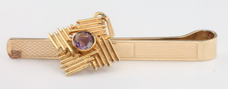 A 9ct yellow gold engine turned tie clip and a 9ct gold pendant set with an amethyst 