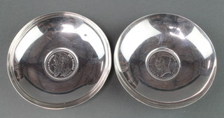 A pair of sterling silver coin set nut dishes 