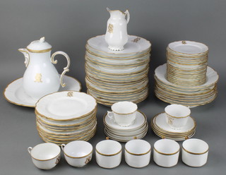 An extensive Victorian gilt decorated dinner service comprising 4 tea cups, 1 saucer, a coffee pot, milk jug, 18 small plates, 12 medium plates, 20 dinner plates, 1 large serving plate, 8 soup bowls, all decorated with a monogram together with a part coffee set comprising 4 coffee cans and saucers 