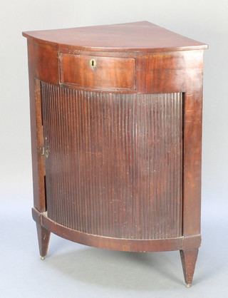 A 19th Century mahogany corner cabinet, the upper section fitted a drawer above a cupboard enclosed by a tambour shutter, raised on square tapering supports 36"h x 27 1/2"w x 19"d 