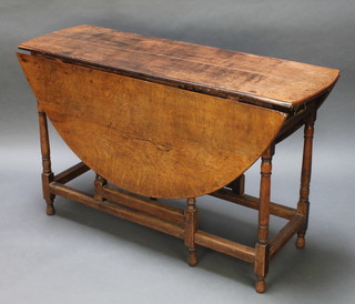 An 18th Century oak drop flap gateleg dining table fitted a drawer raised on turned and block supports 29 1/2"h x 48"w x 16" when closed x 52" when open 