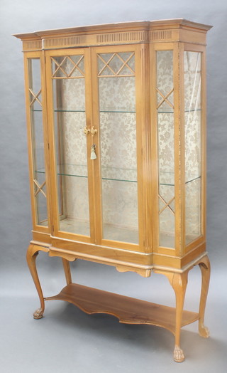 A Georgian style bleached mahogany breakfront display cabinet the upper section with moulded cornice, fitted shelves enclosed by glazed panelled doors, raised on cabriole and paw supports 77"h x 48"w x 18"d 