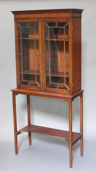 An Edwardian Georgian style mahogany display cabinet on stand, the upper section with moulded cornice fitted adjustable shelves enclosed by astragal glazed panelled doors, the base fitted an undertier on square tapering supports 60"h x 27"w x 12"d 