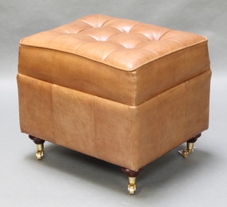 A rectangular Victorian style tan leather footstool raised on turned supports with brass casters 20"h x 24"w x 19"d 