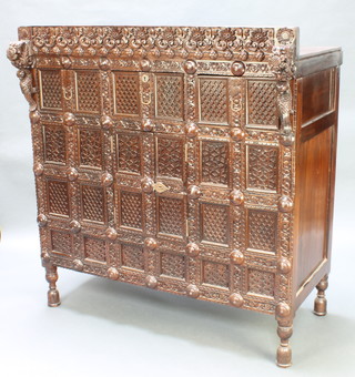 An Indian heavily carved rosewood cabinet with blind fret work decoration, fitted 3 short drawers with cupboard enclosed by panelled door, raised on bun feet 56"h x 52 1/2"w x 30"d 