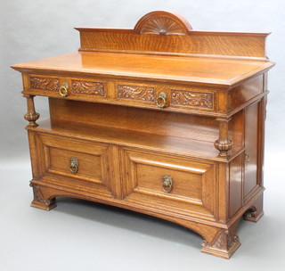 Wylie and Lochhead Ltd of Glasgow, a Victorian heavily carved oak table leaf bearing buffet, the upper section with arched back the base fitted 2 drawers above a recess, the base fitted a cupboard enclosed by panelled doors on shaped supports, the interior fitted 7 bays for dining table leaves and enclosed by panelled doors 53"h x 61 1/2"w x 27"d 