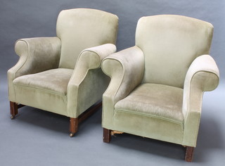 A pair of club style armchairs upholstered in green Dralon raised on square oak supports with H framed stretcher